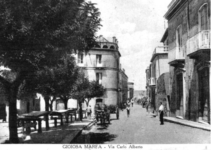 Un'antica foto di via carlo alberto a gioiosa marea in sicilia. Nella fotografia anche un carretto siciliano tipico